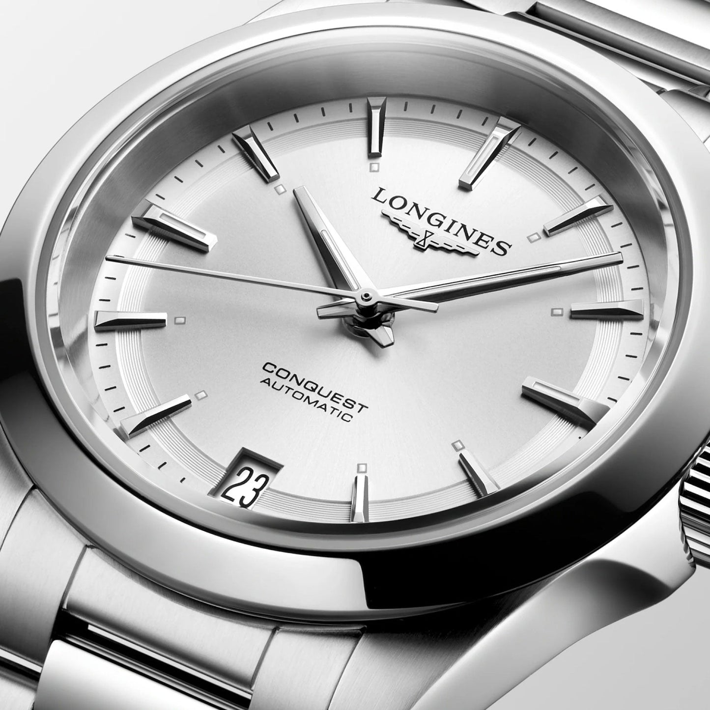 A close-up of a Longines Conquest Automatic 34mm Watch showcases the brand's signature elegance. The dial prominently displays the word "Conquest" and "Automatic," along with a date display at 3 o'clock, while its sleek metal bracelet accentuates its sophisticated performance.