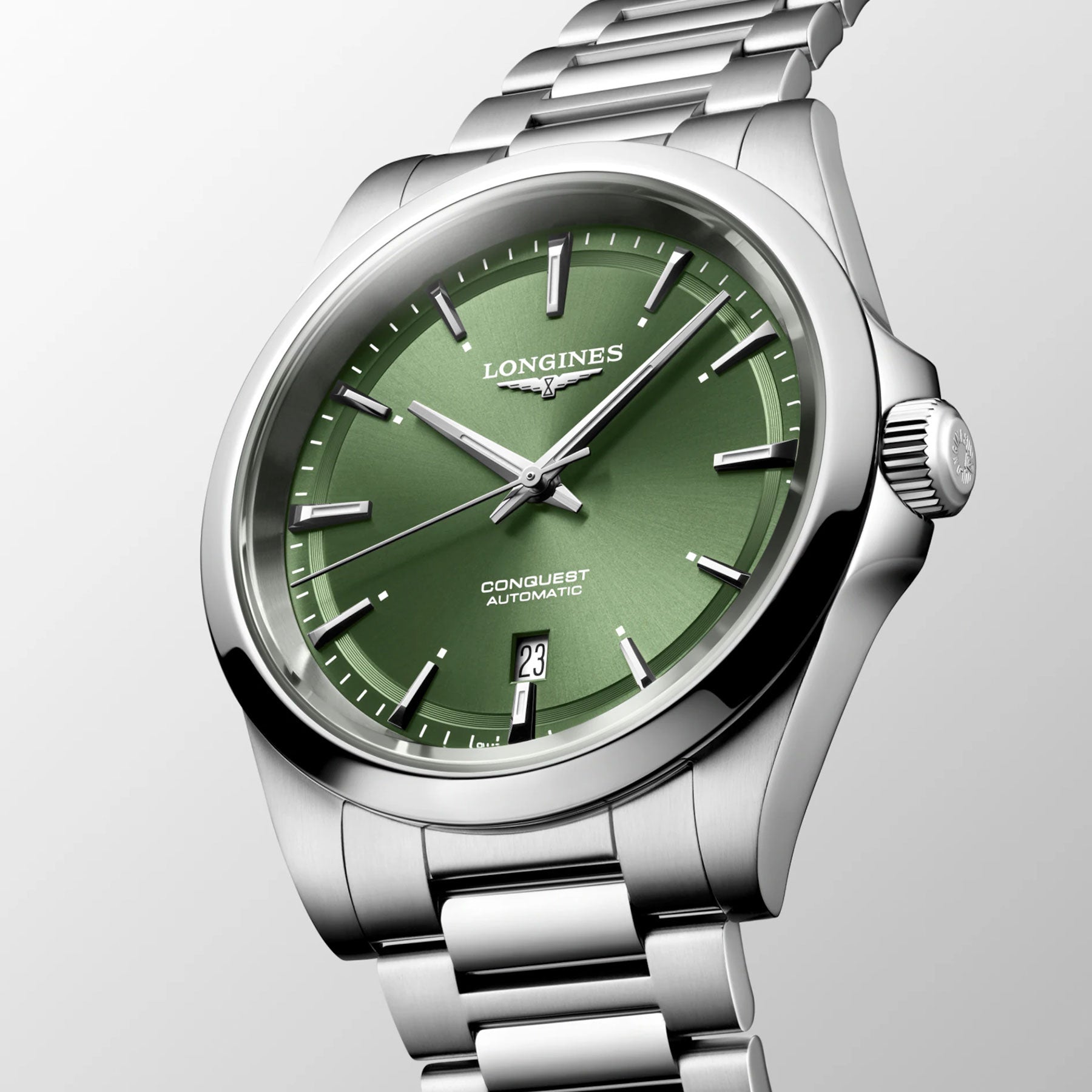 The Longines Conquest Automatic 41mm Watch, featuring a silver case and a green dial adorned with the Longines logo and "Conquest Automatic" inscription, epitomizes elegance. It includes a date window at the 3 o'clock position and sleek silver hour markers, set against a light grey background, offering unparalleled performance in style.