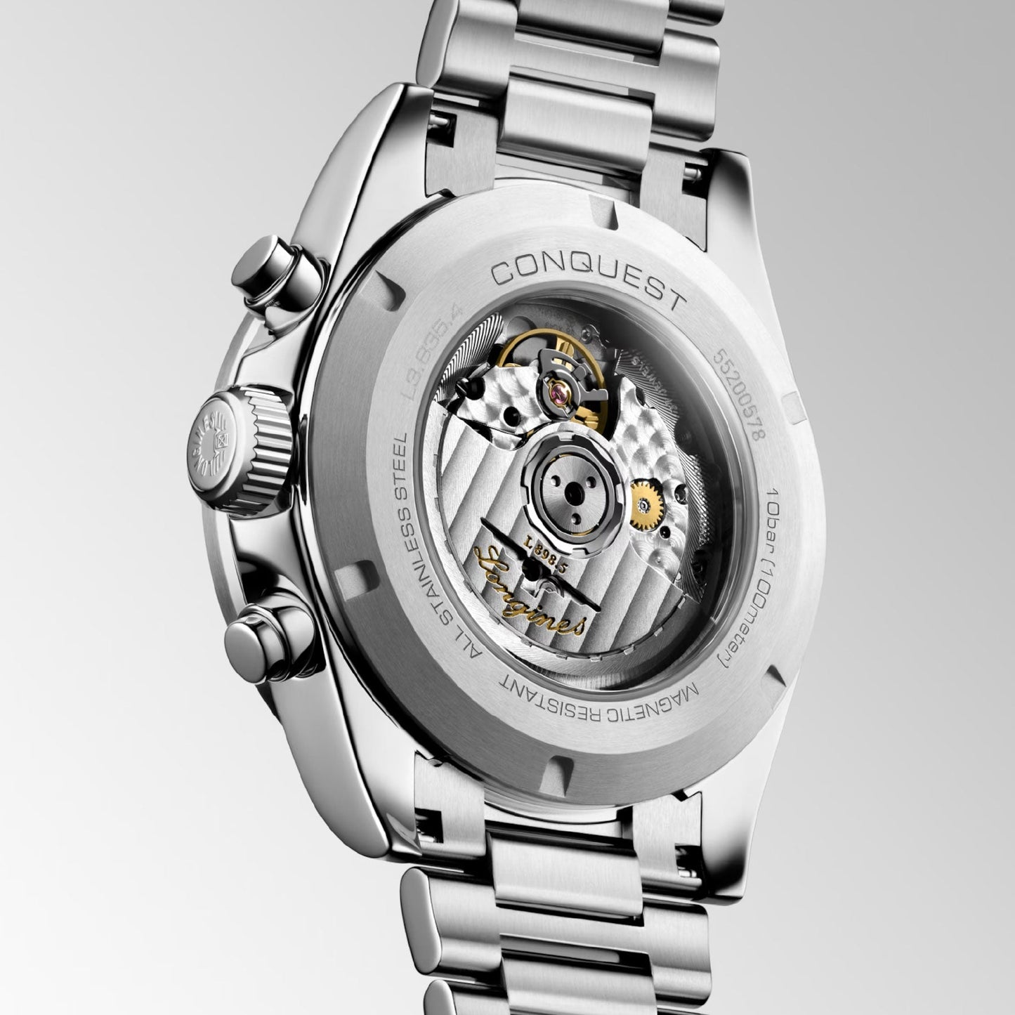 The image features the back of the Longines Conquest Automatic 42mm Watch, displaying its stainless steel design and a transparent case that reveals detailed mechanical components. Elegance is captured in the engraved word "Conquest" on the outer rim, while its metallic bracelet reflects refined performance.