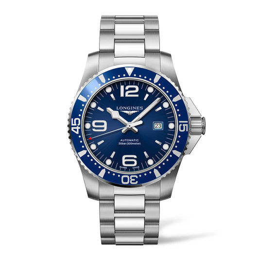 The Longines HydroConquest Automatic 43mm Watch by Longines features a stainless steel design with a blue dial and bezel, showcasing large white numerals, a date window at 3 o'clock, and luminous hands. It comes with a metal bracelet and is marked for 300m water resistance.