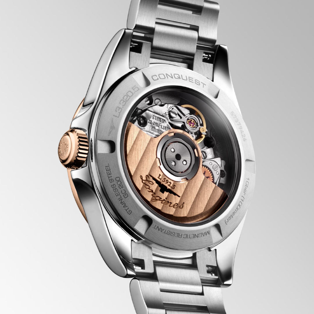 Close-up of the back of the Longines Conquest Automatic 30mm, displaying its engraved gold rotor and mechanical movement—a stainless steel watch blending sporty elegance and fine craftsmanship by Longines.