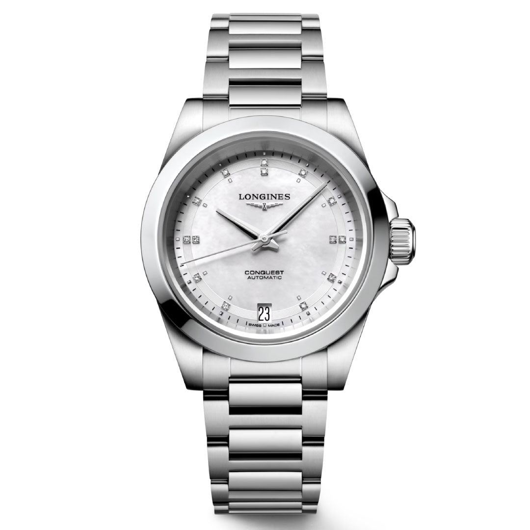 The Longines Conquest Automatic 34mm Watch epitomizes timeless elegance with its metal bracelet and white dial. Its dial is adorned with slim baton hour markers, a date window at 3 o'clock, and elegant hands that highlight high performance. The brand name, Longines, and model are prominently displayed.