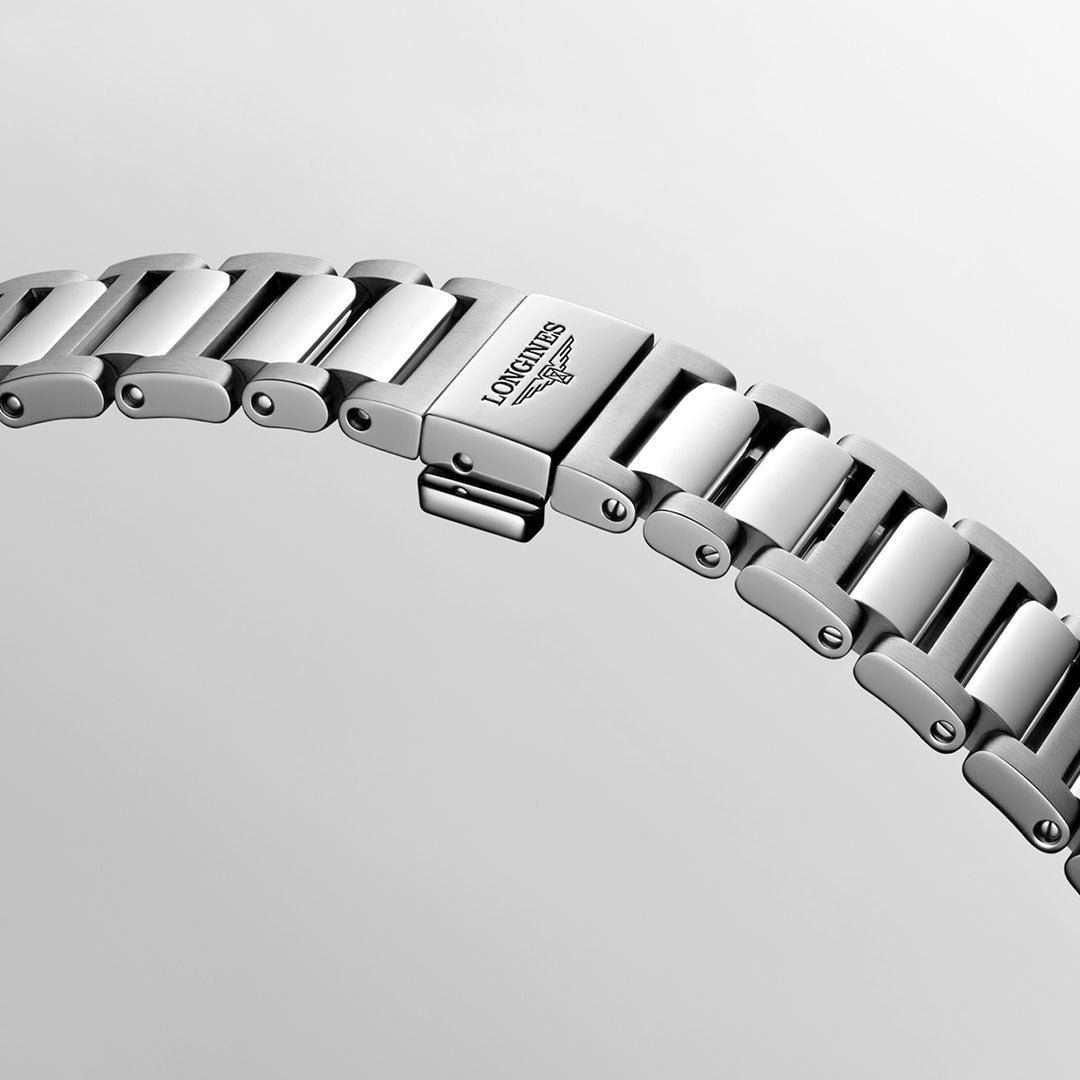 A close-up of a silver metal watch bracelet, belonging to the Longines Conquest Automatic 34mm Watch, features a clasp engraved with the brand name "Longines," showcasing the elegance of precise craftsmanship. The polished links from Longines' esteemed collection stand out against a plain light gray background.