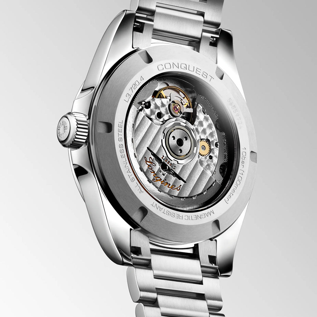 Close-up of the Longines Conquest Automatic 38mm Watch’s stainless steel back, displaying its self-winding mechanical movement with visible gears and engraved “LONGINES” and “CONQUEST” on a silver bracelet.