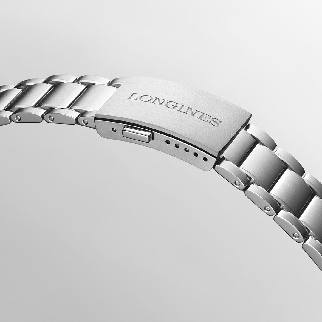 A detailed view of the silver metal bracelet from the Longines Spirit Flyback Automatic Chronograph 42mm Watch highlights the engraved "Longines" brand name, accented by its signature winged hourglass emblem. The segmented links shine against a sleek, neutral gray background, embodying the timeless elegance of the Longines Spirit collection.