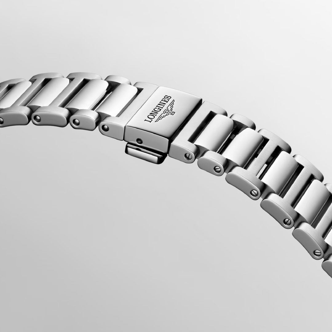 A detailed view of the Longines Conquest Automatic 41mm watch bracelet highlights its silver finish with an embossed logo clasp, embodying elegance and the essence of Conquest. The polished, reflective links gleam beautifully against a light grey backdrop.