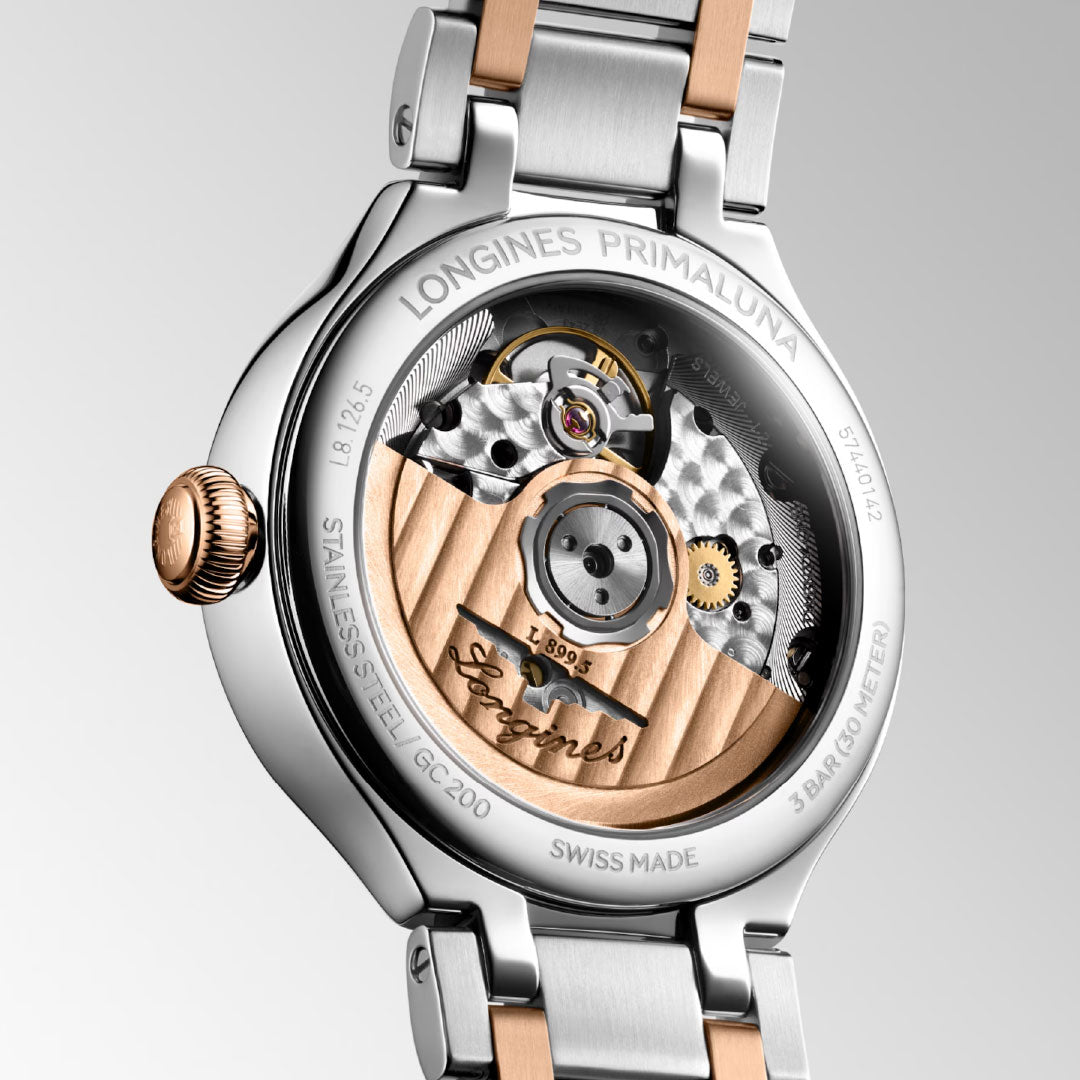 Close-up of the Longines Primaluna Moonphase Automatic 34mm Watch back, displaying its refined Swiss mechanical movement with gold and silver details, intricate engravings, and the "Longines" signature on the rotor.