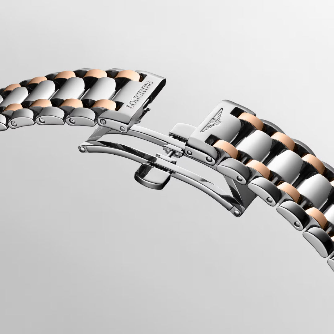 A close-up of the Longines Primaluna Moonphase Automatic 34mm’s stainless steel and rose gold bracelet with a butterfly clasp, featuring the engraved Longines logo—a refined detail for this elegant women’s watch.