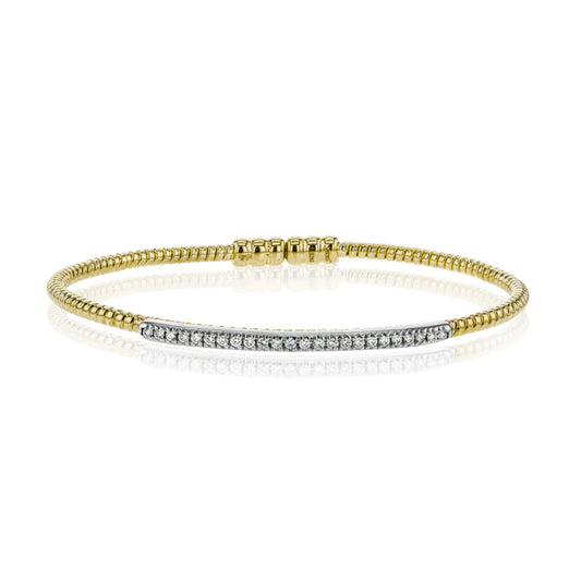 The Simon G. 18K Yellow Gold Diamond Bangle by Simon G showcases a thin band embellished with a row of dazzling white diamonds arranged in a straight line across the front. This bracelet has a reflective surface, producing a mirror-like effect against a white background.