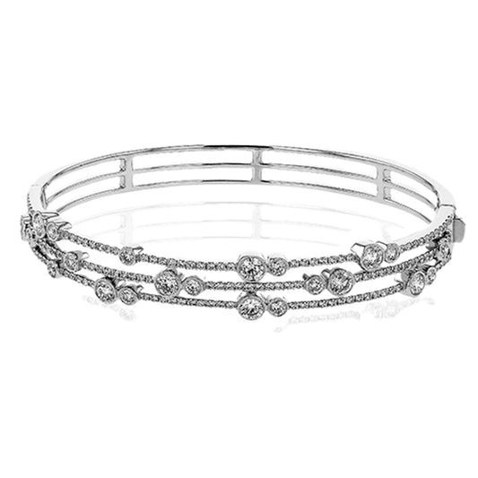 The Simon G. 18K White Gold Diamond Bangle, crafted by Simon G, features three layered bands adorned with round diamonds. This sophisticated piece boasts a polished and reflective design, epitomizing luxury and elegance.