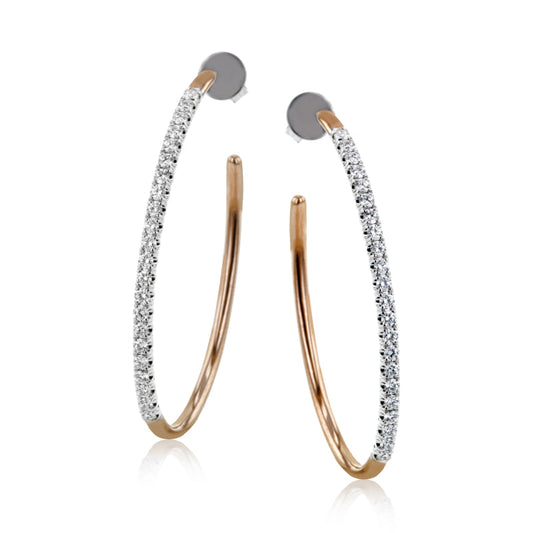 A pair of elegant, slender hoop earrings with intricate gold detailing, adorned with small, sparkling diamonds that brilliantly catch the light. These Simon G. 18K White and Yellow Gold Diamond Earrings are showcased vertically against a white background.