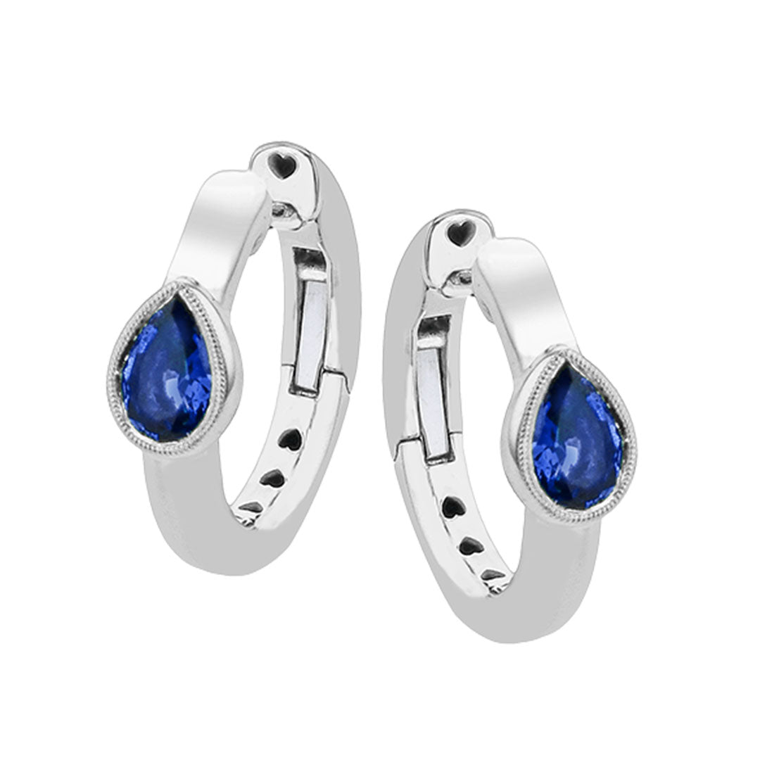 The Simon G. 18K White Gold Diamond and Sapphire Hoop Earrings feature faceted pear-shaped blue sapphires (0.90 CTW) set in silver hoops, each framed by a delicate border from luxury brand Simon G.
