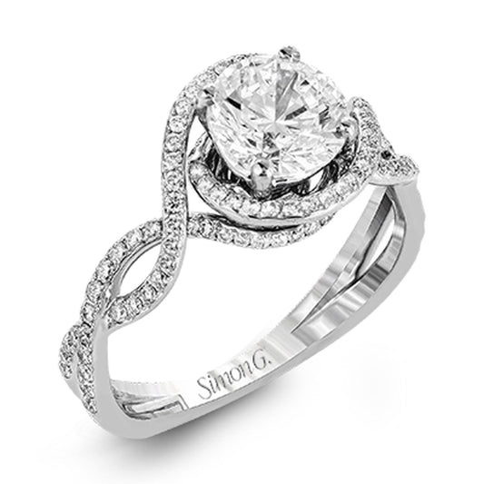 The Simon G. 18K White Gold Round Brilliant Diamond Ring features a large round diamond at its center, surrounded by smaller white diamonds, similar to a silver engagement ring. The band showcases an intricate twisting openwork design adorned with additional small diamonds, with "Simon G" engraved inside.