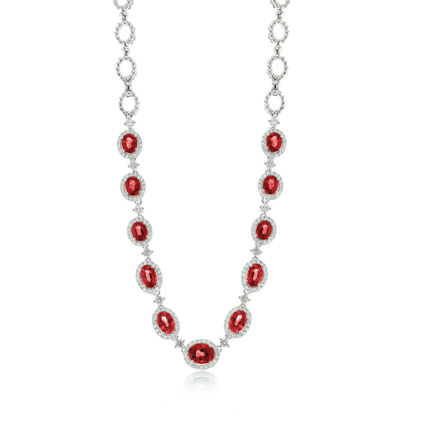 This Simon G. 18K White Gold Ruby with Diamond Necklace features oval red rubies, each surrounded by small clear diamonds, connected by circular elements in a symmetrical design on a fine white gold chain.