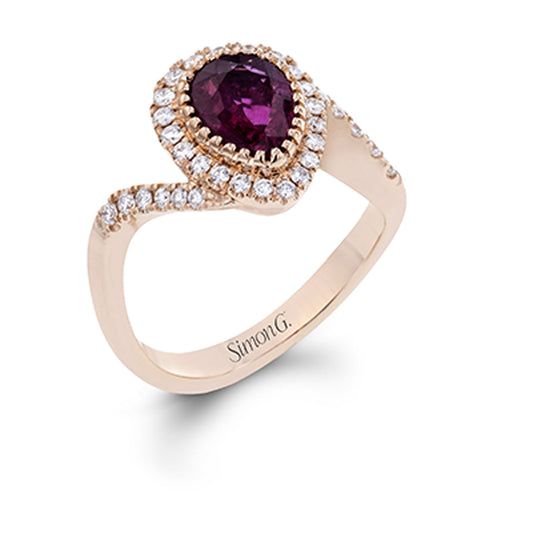 A rose gold ring adorned with a pear-shaped ruby, encircled by a halo of white diamonds and additional diamonds along the band, featuring the inscription "Simon G." on the side.