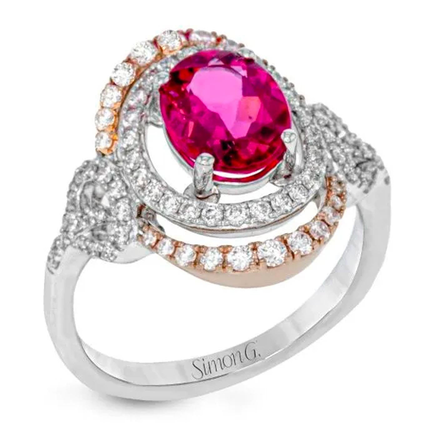 Introducing the exquisite Simon G. 18K White and Yellow Gold Rubelite with Diamond Ring, featuring a captivating oval red rubellite tourmaline centerpiece encircled by a halo of sparkling round diamonds. This intricate design is further enhanced by additional diamond accents adorning the band.