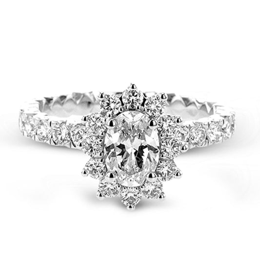 The Simon G. 18K White Gold Sapphire with Diamond Ring features a striking oval center stone encircled by a halo of smaller diamonds. The band is embellished with additional diamonds, resulting in an elegant and sparkling design.