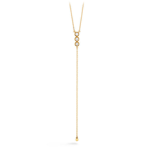 Introducing the Hearts On Fire Liliana Milgrain Lariat Necklace by Hearts on Fire, a stunning 18 Karat Yellow Gold creation. This exquisite piece showcases a delicate lariat chain with two interlocking loops embellished with small diamonds. Completing the elegant design, a long, single chain extends downward and features a small gold bead at its end.