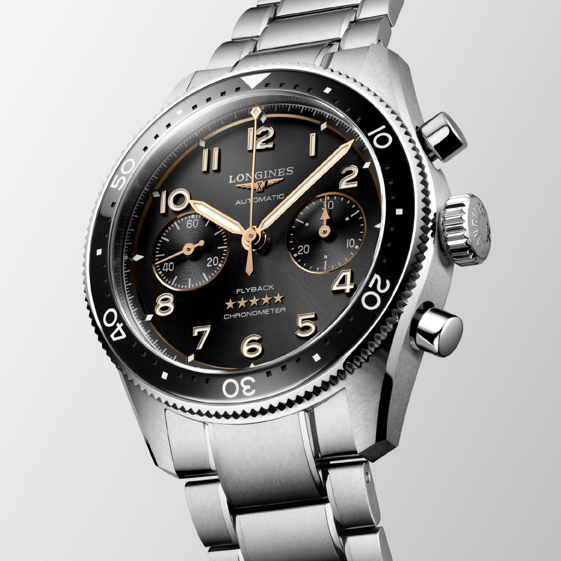 This close-up highlights the Longines Spirit Flyback Automatic Chronograph 42mm Watch, featuring a stainless steel case with a black dial adorned with Arabic numerals, three subdials, and a bezel with minute markings. The timepiece is complemented by a polished silver bracelet and prominent side push-buttons, epitomizing Longines' legacy as legendary pioneers in watchmaking.