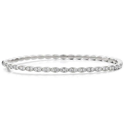 The Hearts On Fire Lorelei Floral Bangle Bracelet is a stunning piece, featuring a continuous line of sparkling round diamonds. Set along its elegant silver or white gold band, this bracelet is an exquisite standout in any Jewelry Collection and embodies the sophistication synonymous with Hearts On Fire creations.