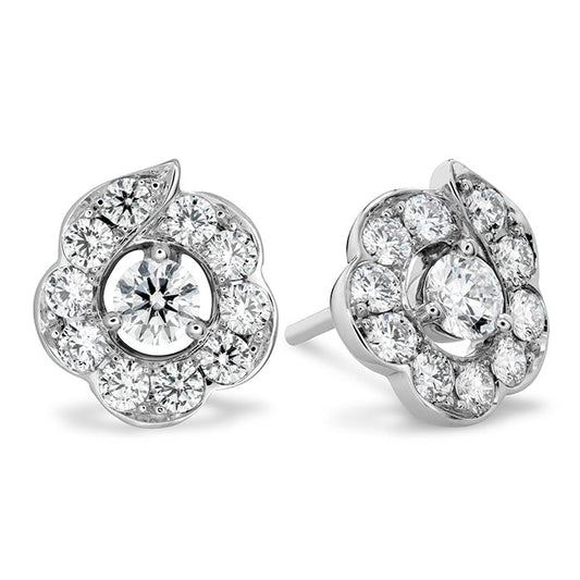 The Hearts On Fire Lorelei Bloom Stud Earrings by Hearts on Fire boast silver floral motifs adorned with circular diamond clusters. These earrings emphasize a prominent central stone encircled by smaller diamonds, offering elegance and sparkle for a stunning appearance.