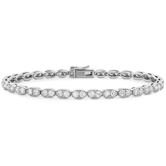 The Hearts On Fire Lorelei Floral Line Bracelet, crafted from 18 Karat White Gold with oval links adorned with radiant, small diamond-like stones, showcases exquisite craftsmanship against a plain white backdrop.
