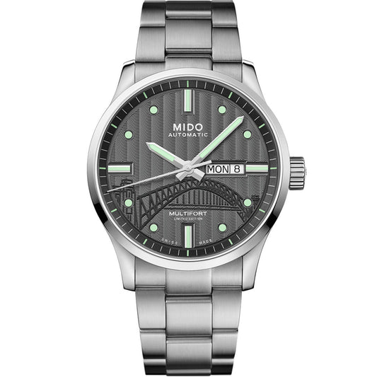 The MIDO Multifort 20th Anniversary Limited Edition Automatic 42mm watch features a black textured dial with green markers, day/date display, decorative bridge design, and a metal band—limited to 1932 pieces.