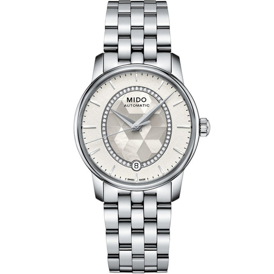The MIDO Baroncelli II Prisma Automatic 33mm features a silver metallic link band, textured light dial, slim hour markers, and a date display at 6 o’clock.