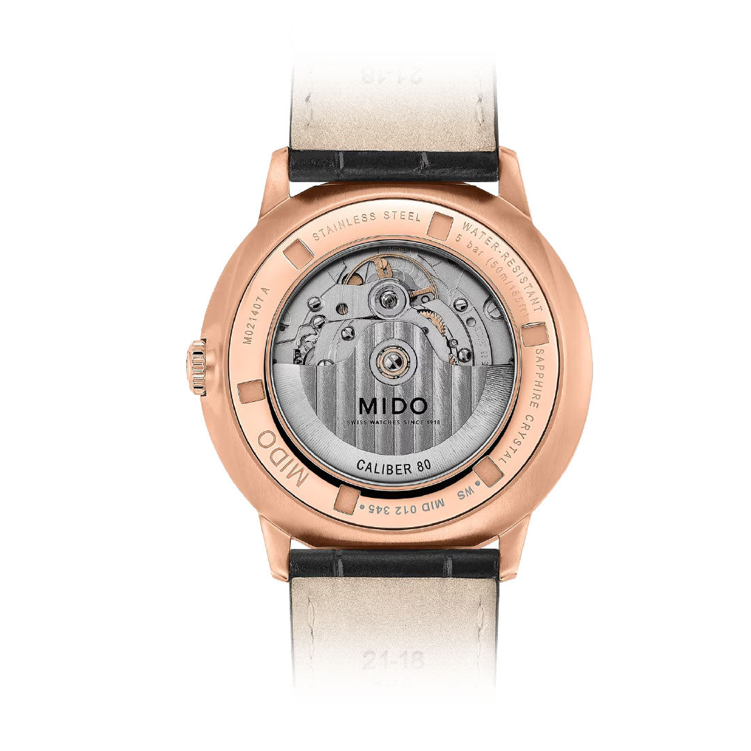 Close-up of the MIDO Commander Gradient Automatic 40mm Watch, displaying its Caliber 80 movement through a transparent case back with a rose gold-tone stainless steel frame and leather strap.