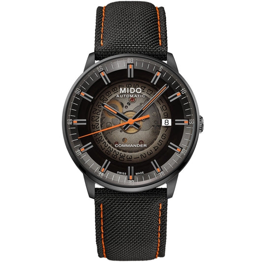 The MIDO Commander Gradient Automatic 40mm Watch features a black textured strap with orange stitching, a transparent dial showing gears, silver hour markers, orange hands, Caliber 80 movement, date at 3 o’clock, and “Commander” above 6.