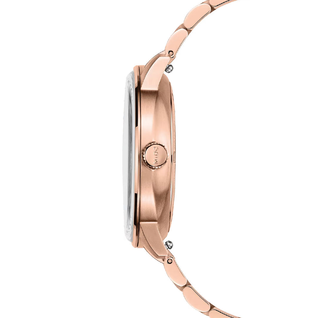 Side view of the MIDO Commander Datoday Automatic 40mm Watch featuring a slim, rose gold stainless steel case, metal link band, and crown with "MIDO" engraved—showcasing timeless elegance.