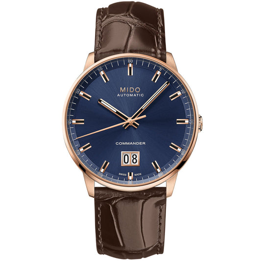 The MIDO Commander Big Date Automatic 42mm Watch features a blue dial, gold-tone case, gold hour markers and hands, brown leather strap, and date display at 6 o'clock with "MIDO AUTOMATIC" below 12 o'clock.