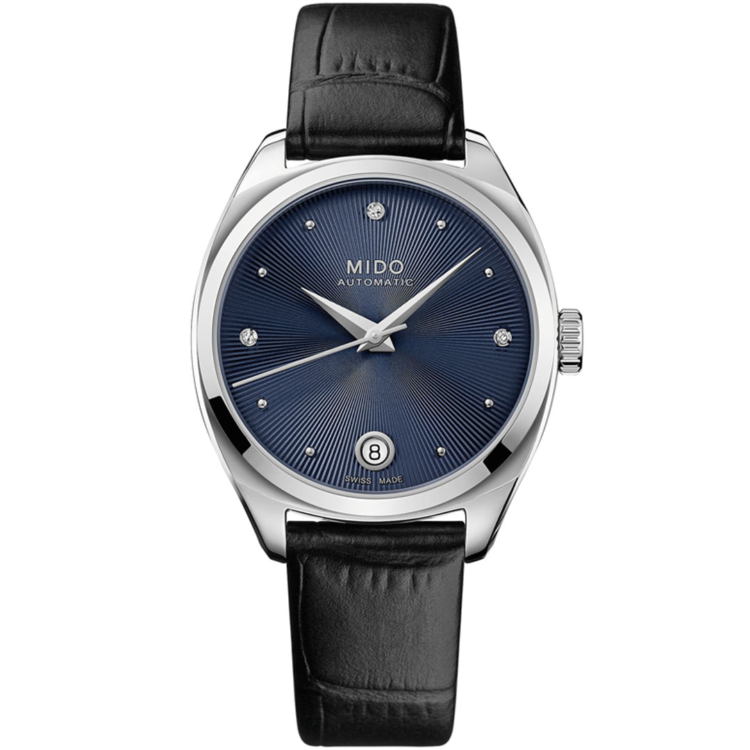 The MIDO Belluna Royal Lady Automatic 33.4mm Watch features a dark blue sunburst dial, silver hour markers, date window at 6 o’clock, black leather strap, and a sleek silver case for a refined minimalist look.