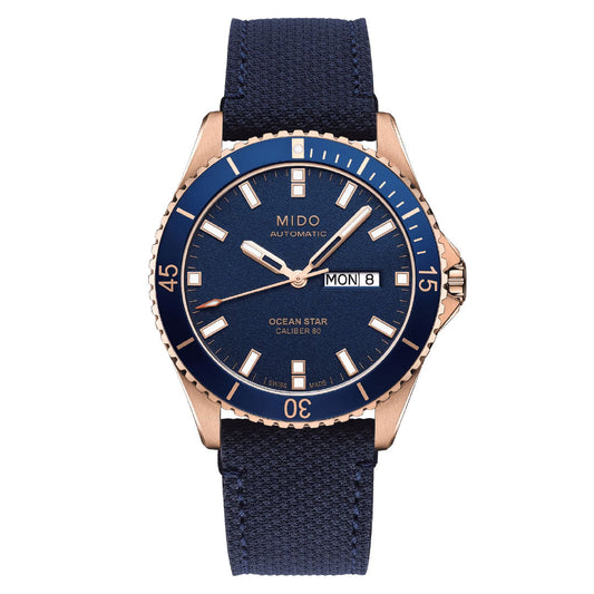 The MIDO Ocean Star 200 Automatic 42.5mm Watch features a blue dial, gold-tone case, blue bezel and fabric strap, with day/date displays, white markers and hands. Water resistant for daily use. Brand: MIDO.