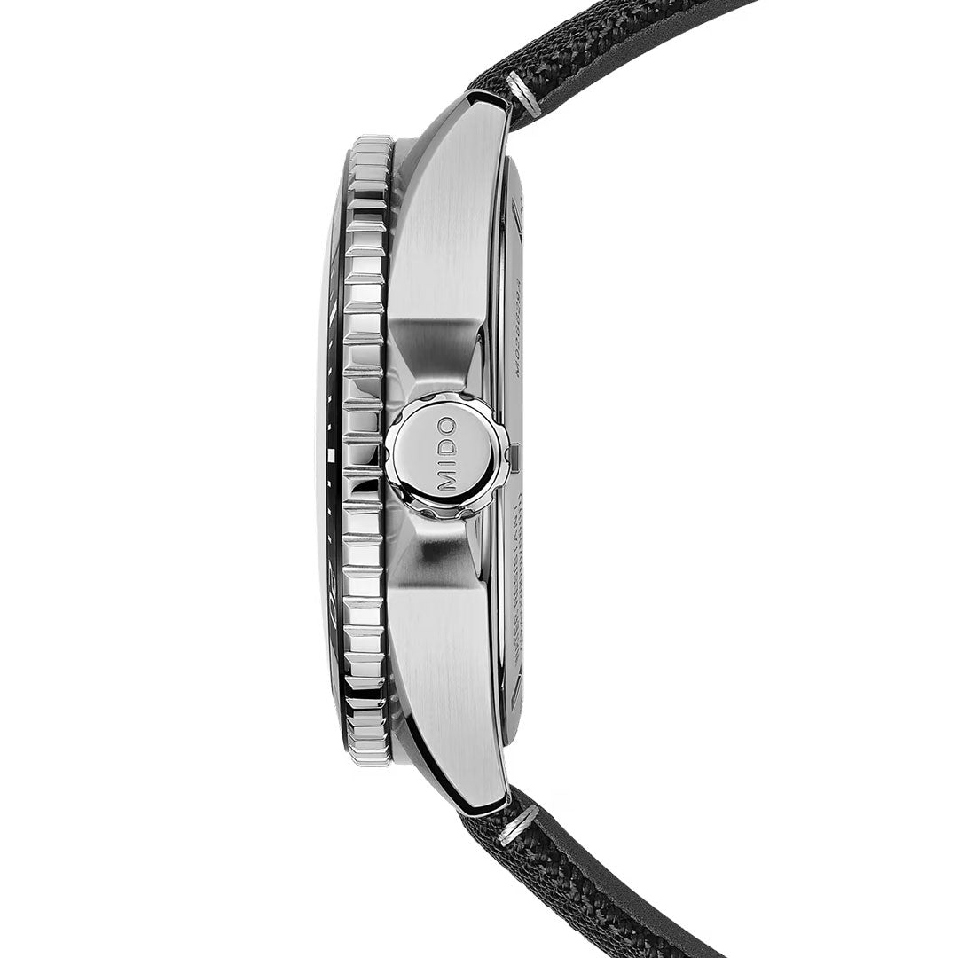 Side view of the MIDO Ocean Star GMT Automatic 44mm Watch, featuring a brushed stainless steel case, a ridged bezel, and a textured black strap. The crown is engraved with "MIDO," highlighting its sleek and modern diving watch design.