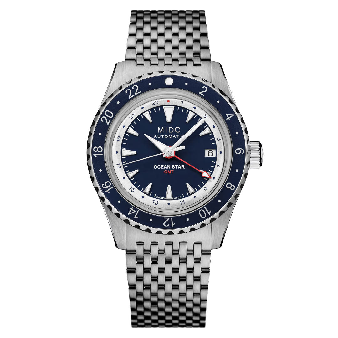 The MIDO Ocean Star Tribute GMT Automatic 40.5mm Watch features a blue and white bezel, blue dial with red GMT hand, Caliber 80 movement, date at 3 o'clock, and a silver stainless steel woven bracelet.