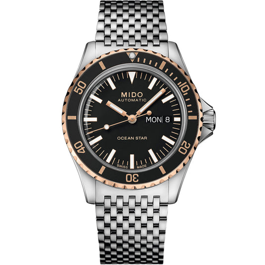 The MIDO Ocean Star Tribute Automatic 40.5mm watch by MIDO features a black dial, silver and rose gold bezel, silver markers, day-date window (Monday 8), and a silver metal link bracelet. The time displayed is 10:10.