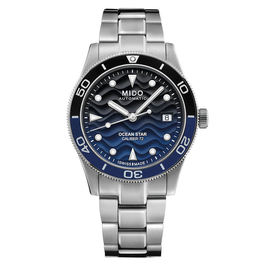 The MIDO Ocean Star 39mm Automatic Watch features a stainless steel case, blue wave-patterned dial with date at 3 o'clock, black and blue unidirectional bezel, metal bracelet, bold white markers, and water resistance.