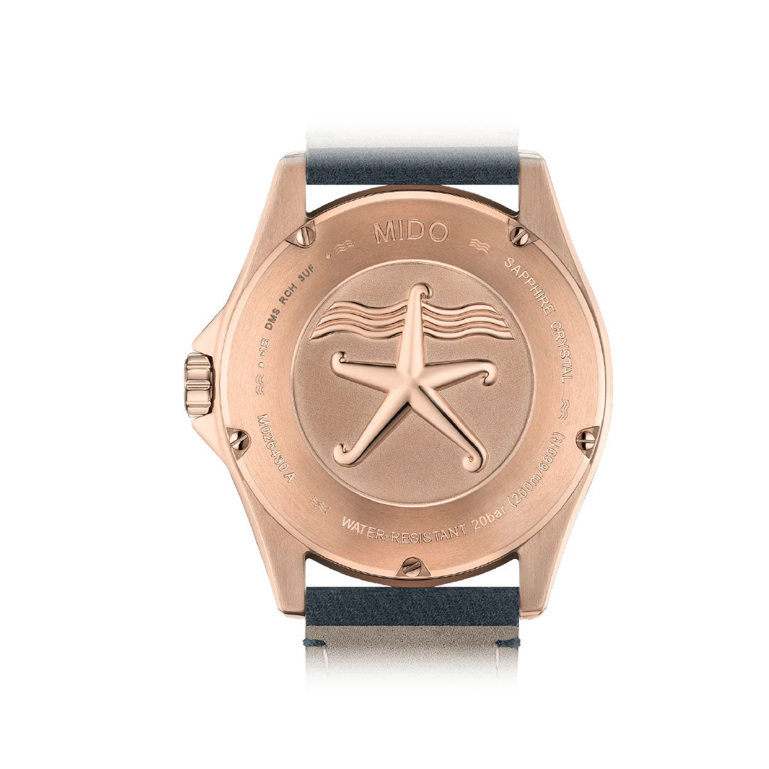 Back view of the MIDO Ocean Star 39mm Automatic Watch shows a rose gold-tone case with engraved starfish, sapphire crystal and water resistance markings, plus a dark strap; by MIDO.