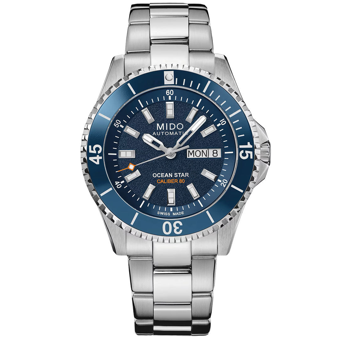 The MIDO Ocean Star 200 Automatic 41mm Watch features a blue dial, day-date display at 3 o’clock, silver hour markers, stainless steel link bracelet, and a blue water-resistant bezel with white numerals.