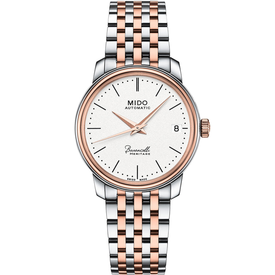 The MIDO Baroncelli III Heritage Lady Automatic 33mm watch features a white dial, rose gold and silver two-tone bracelet, rose gold hands and markers, date window at 3 o’clock, and displays "MIDO Automatic" and "Baroncelli Heritage" on the face.