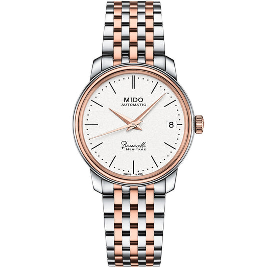 The MIDO Baroncelli III Heritage Lady Automatic 33mm watch features a white dial, rose gold and silver two-tone bracelet, rose gold hands and markers, date window at 3 o’clock, and displays "MIDO Automatic" and "Baroncelli Heritage" on the face.