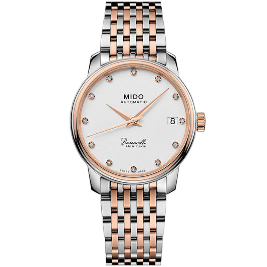 The MIDO Baroncelli III Heritage Lady Automatic 33mm Watch features a silver and rose gold two-tone metal band, white dial with diamond markers, date window at 3 o’clock, and slim hands.