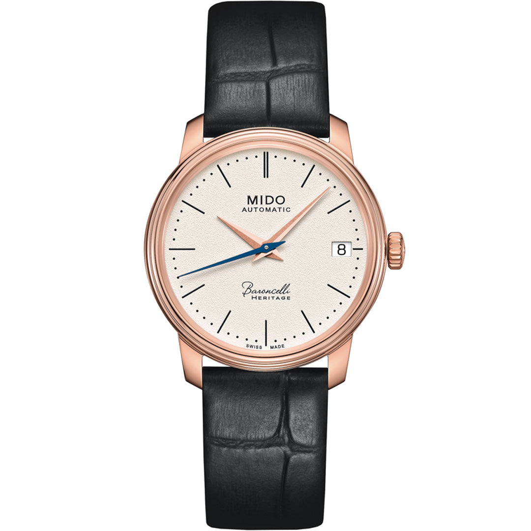 The MIDO Baroncelli III Heritage Lady Automatic 33mm Watch features a white dial, rose gold case, black leather strap, date at 3 o'clock, and simple hour markers—elegance and precision from MIDO.