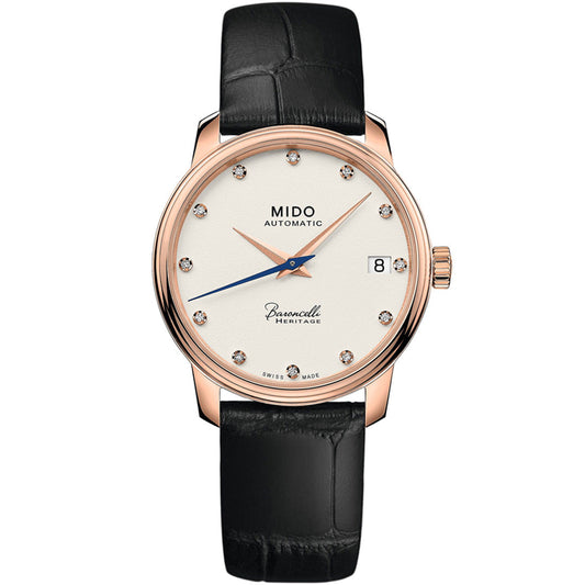 The MIDO Baroncelli III Heritage Lady Automatic 33mm Watch features a white dial, rose gold case, diamond markers, blue second hand, black leather strap, and date at 3—showcasing Swiss elegance.