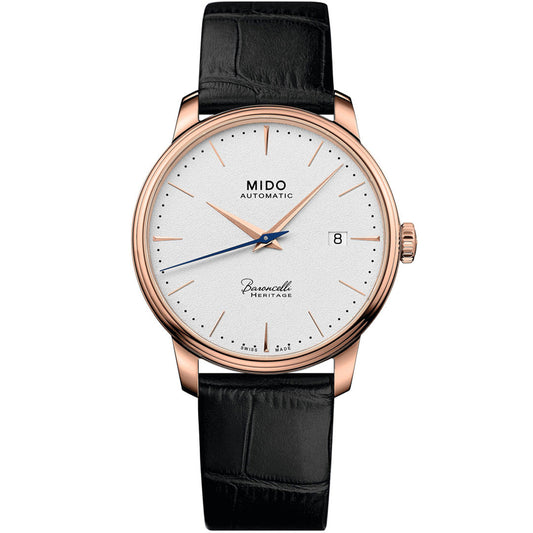 The MIDO Baroncelli Heritage Automatic 39mm watch features a white dial, gold case, black leather strap, slim gold markers and hands, date window at 3 o’clock, and “MIDO Automatic” on the face.