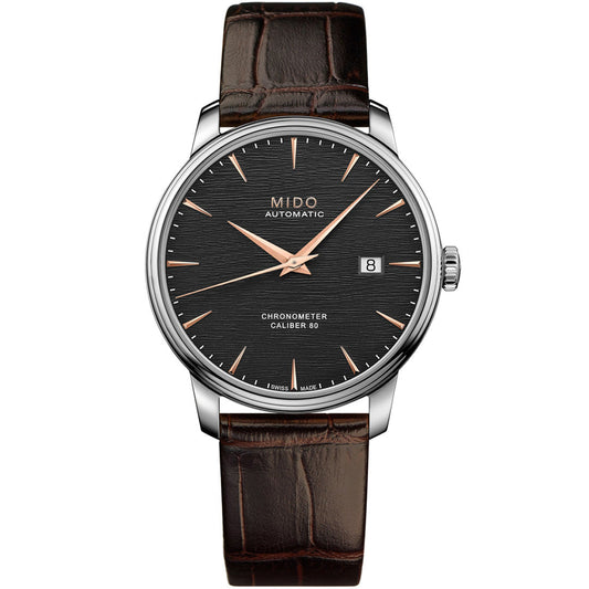 The MIDO Baroncelli III Chronometer Silicon Gent Automatic 40mm Watch features a textured black dial, rose gold hands and markers, date at 3 o’clock, brown leather strap, silver-toned case, and a silicon balance spring for precision.