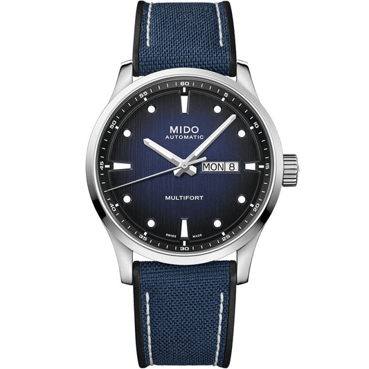 The MIDO Multifort M Automatic 42mm Watch features a blue textured dial, silver markers, day-date display, and blue fabric strap with white stitching. Housed in stainless steel, it runs on Caliber 80 with a Nivachron hairspring.