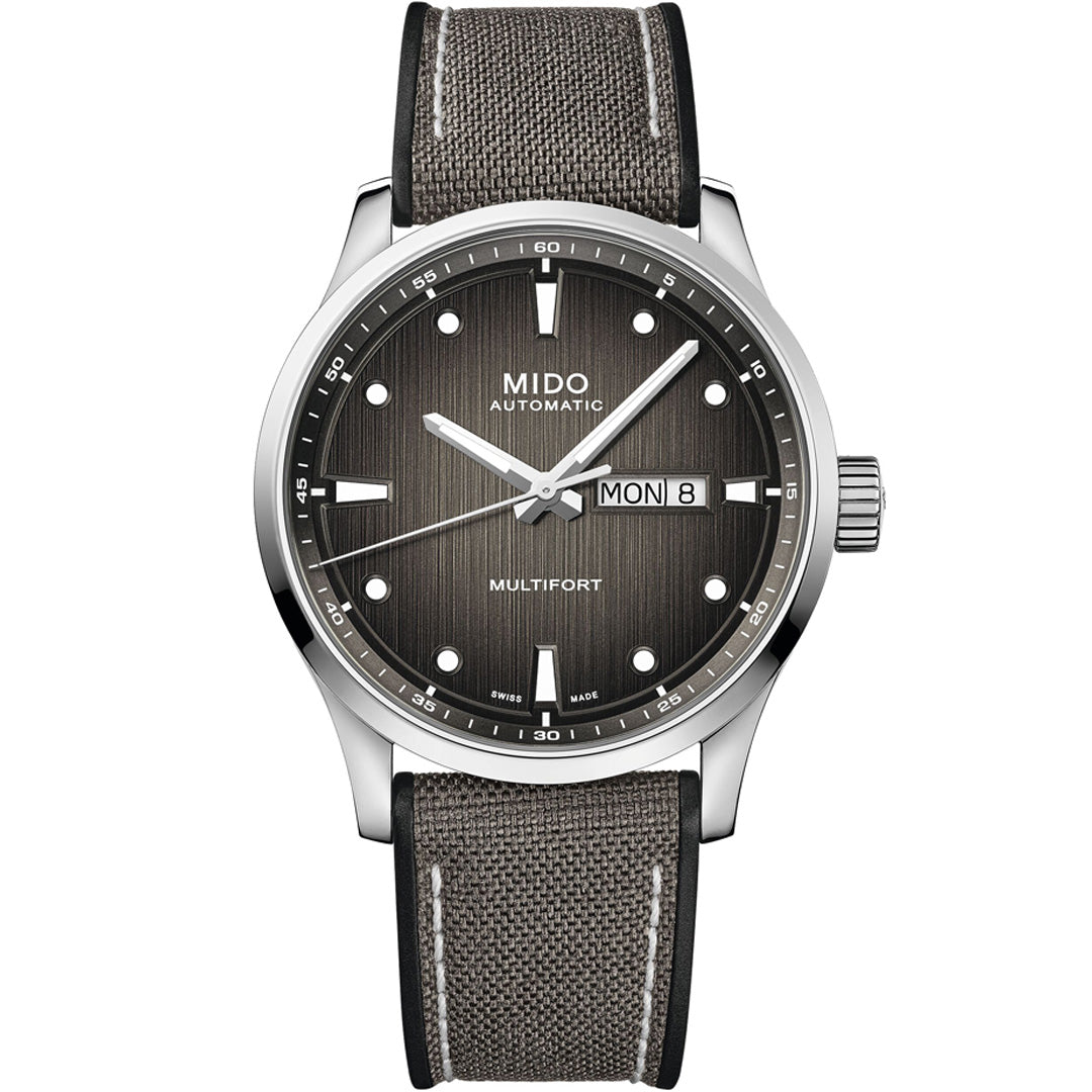 The MIDO Multifort M Automatic 42mm Watch features a textured gray dial, silver hour markers, day-date display at 3 o'clock, and a gray fabric strap with white stitching. Powered by the reliable Caliber 80 movement.
