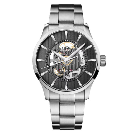 The MIDO Multifort Skeleton Vertigo Automatic 42mm watch features a stainless steel band, black skeleton dial showcasing inner mechanics with silver hour markers, and a transparent section at 6 o'clock.